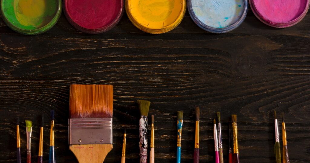 brushes and colours on a wooden board